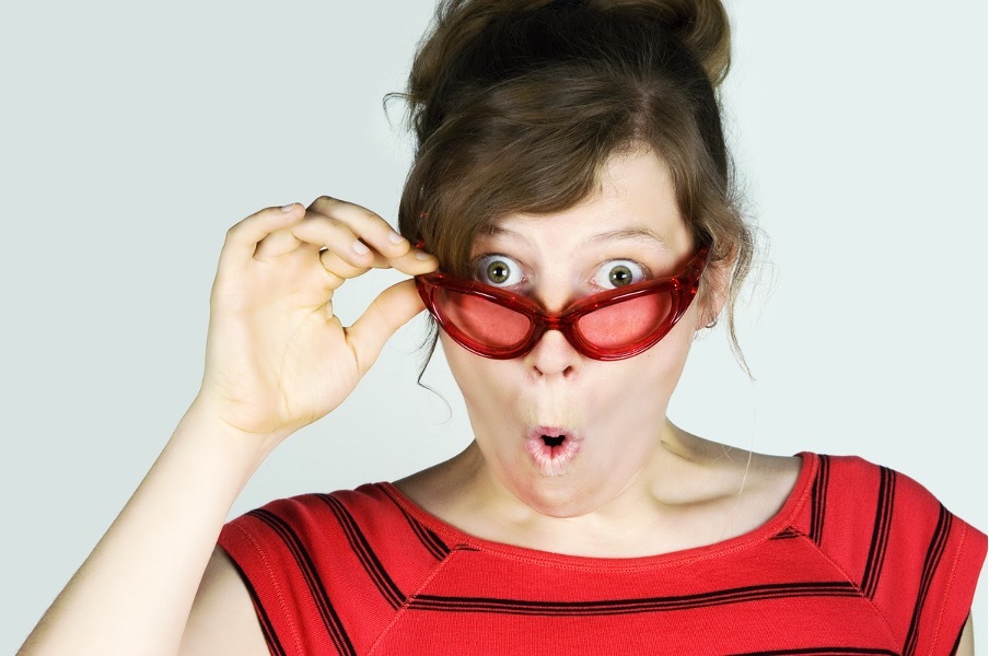 Donna con espressione sorpresa che abbassa gli occhiali, immagine di copertina articolo sui sintomi meno noti della perimenopausa